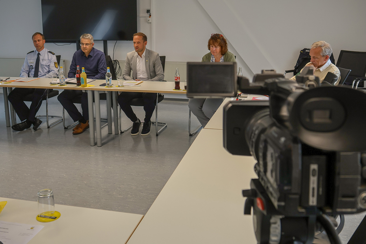 Stadtverwaltung Fünf Personen sitzen hinter einem Tisch, rechts im Vordergrund ist eine Fernsehkamera zu sehen.