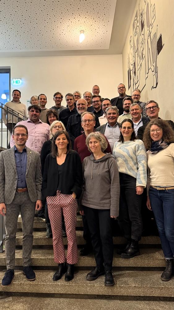 Stadtverwaltung Einige Menschen stehen auf einer Treppe und lächeln in die Kamera