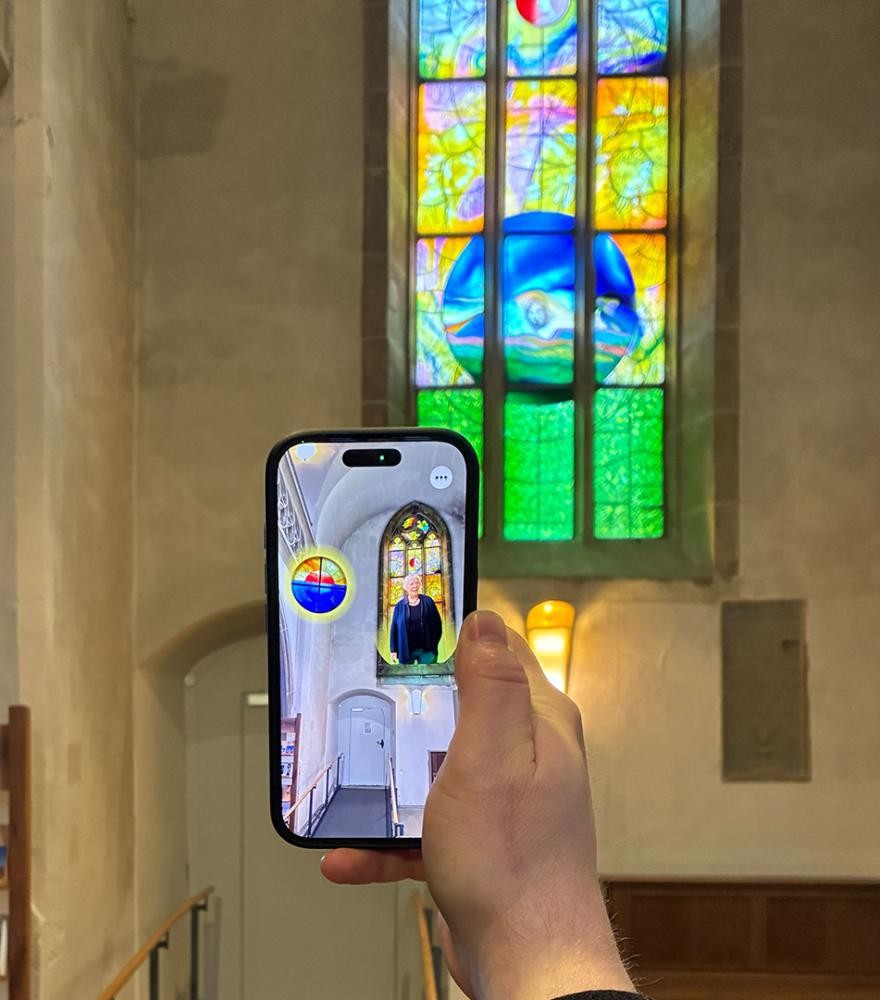 ein Smartphone vor einem bunten Fenster