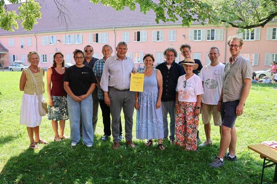 Eine Gruppe von Leuten steht beisammen und lächelt in die Kamera