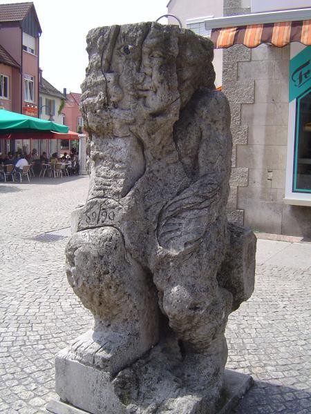 Eine steinerne Skulptur auf einem gepflasterten Platz
