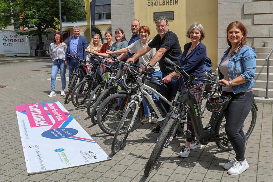 Mehrere Menschen mit ihren Rädern lächeln in die Kamera