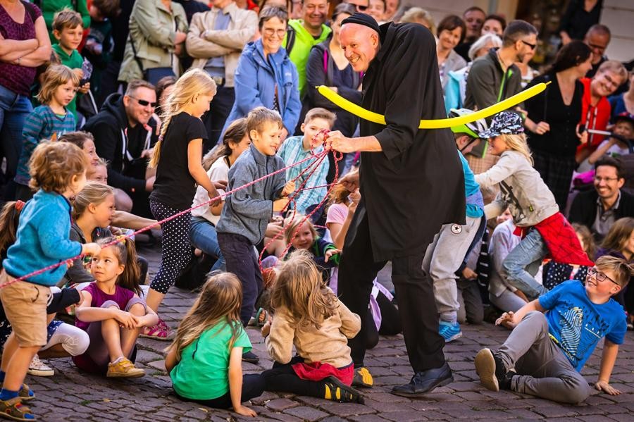 Ein Mann mit Luftballoons inmitten vieler Kinder
