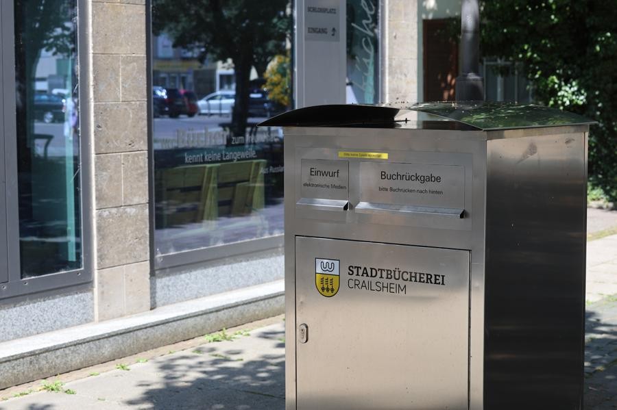 Ein großer silberner Briefkasten vor einem großen Glasfront