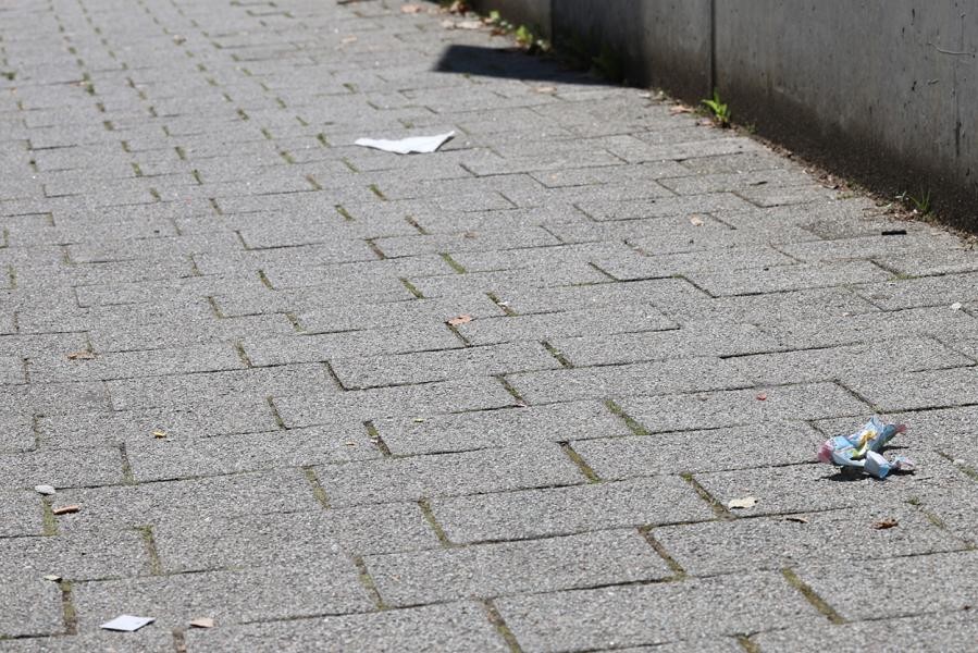 Ein gepflasterter Gehweg mit ein paar Müllutensilien