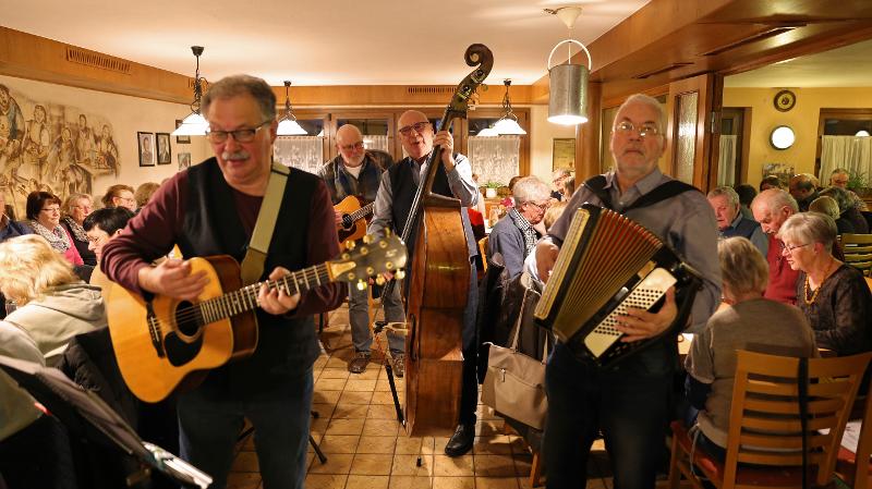 Menschen die in einer Kneipe mit Musikintrustmenten spielen