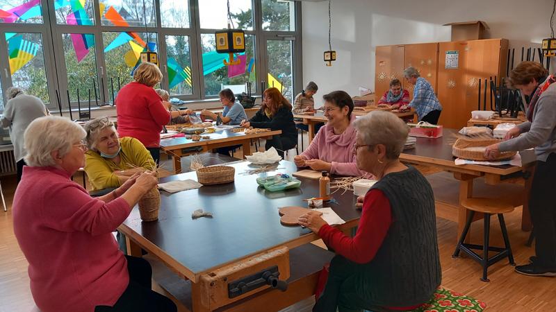 Personengruppe sitzt an einem Tisch und bastelt