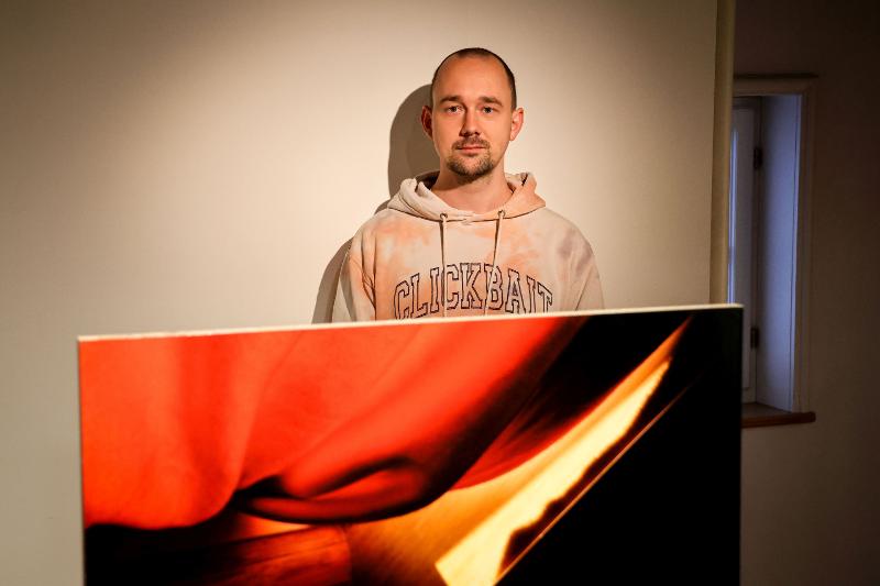 Foto von Tino Zimmermann hinter einem Bild.