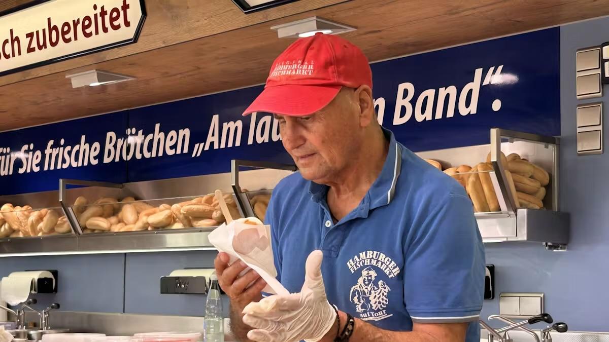 Ein Marktschreier beid er Arbeit in seinem Wagen, der etwas verkauft