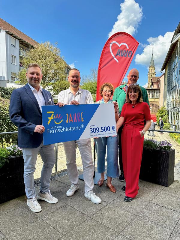 Menschen die einen Spendenschenk der Fernsehlotterie halten