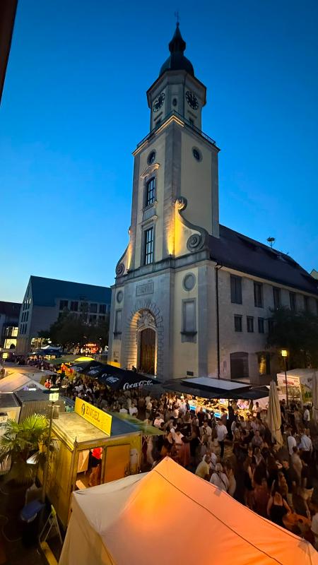 Rathausturm sowie Stände mit vielen Menschen