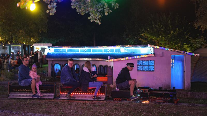 kleine Lokomotiveinsenbahn mit Menschen darauf