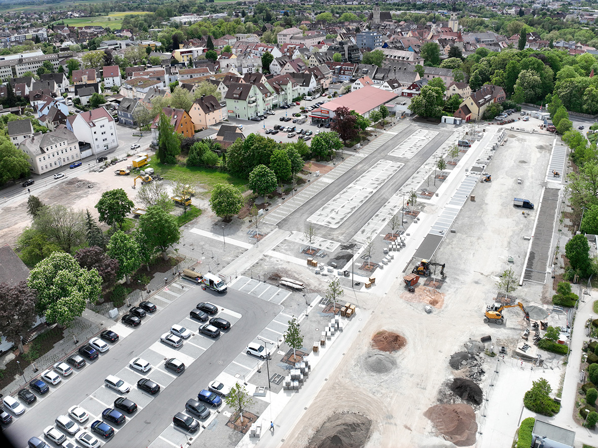 Ein großer Parkplatz aus der Vogelperspektive mit noch unsanierten Teilen