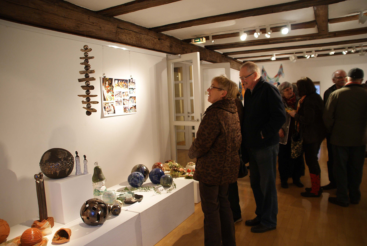 Einige ältere Menschen in einem Ausstellungsraum