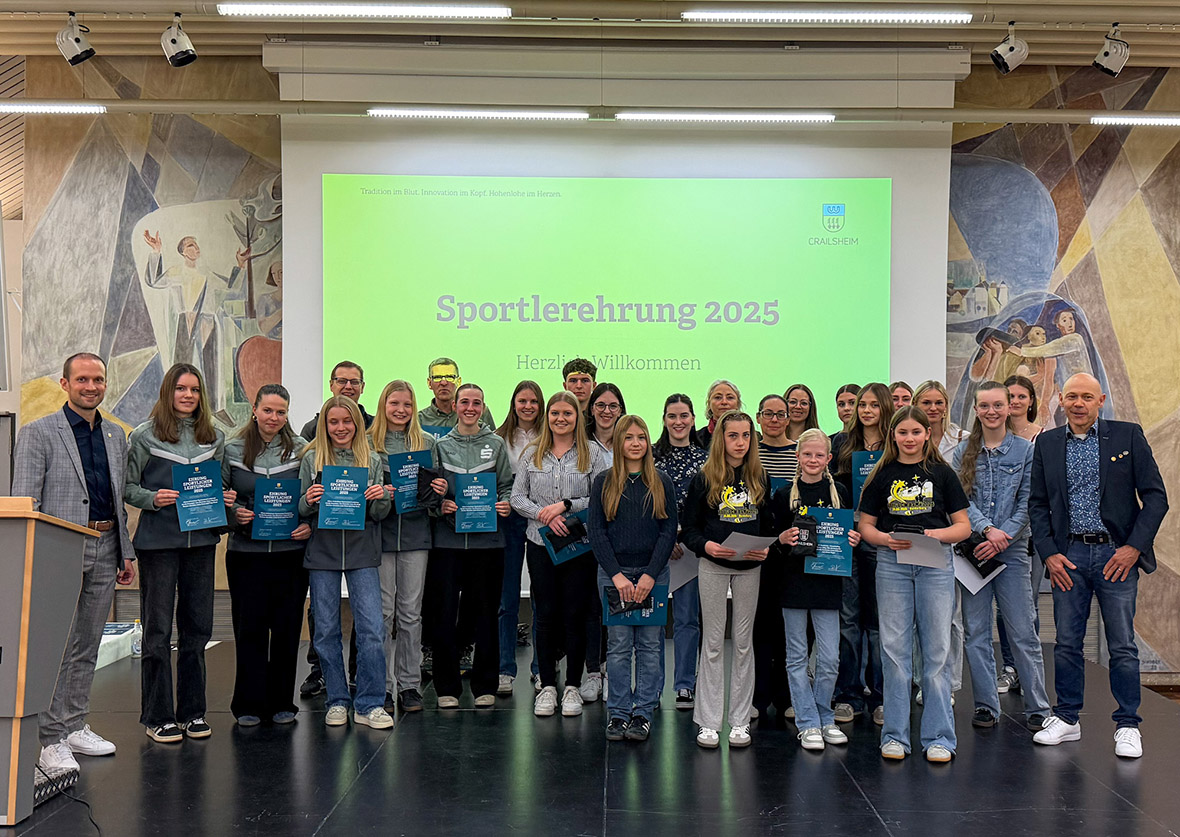 Eine größere Gruppe Menschen steht auf einer Bühne.