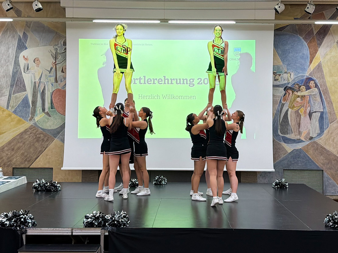 Eine Cheerleadertruppe auf einer erleuchteten Bühne