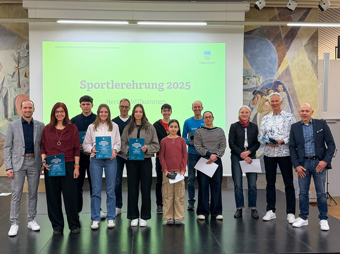 Eine Gruppe von Leuten unterschiedlichen Alters steht auf einer Bühne