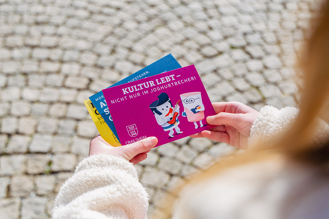 Hände, die bunte Postkarten halten