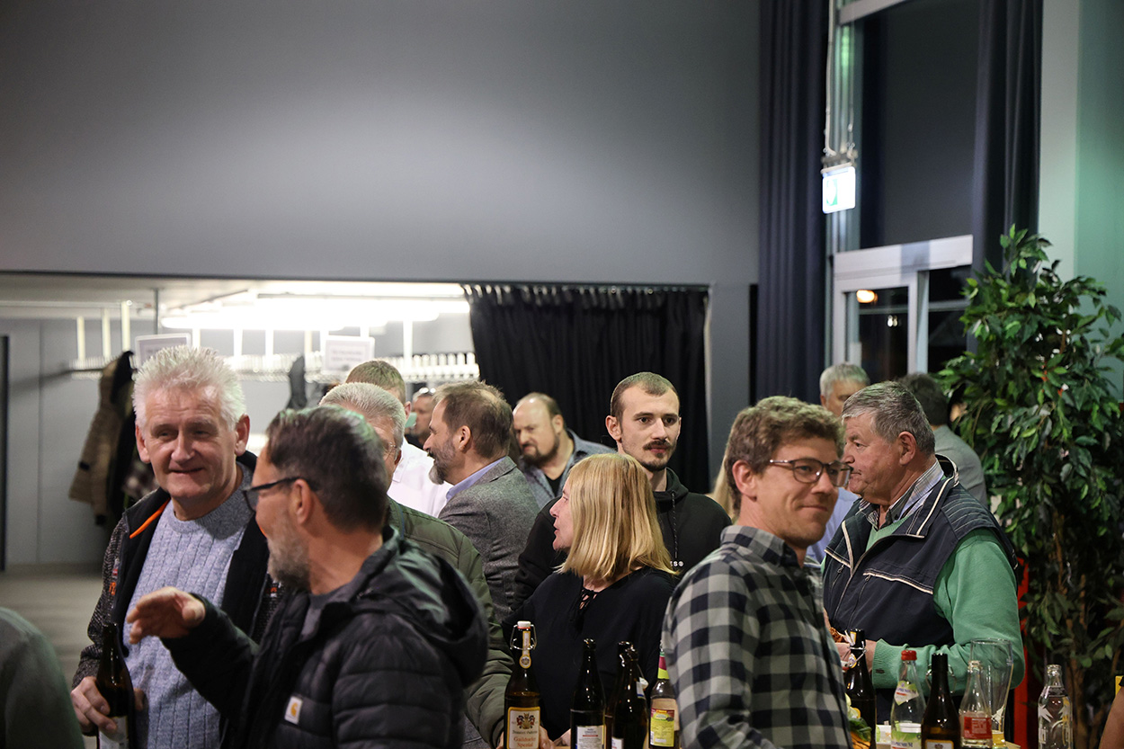 viele Menschen stehen in einer Halle zusammen und unterhalten sich