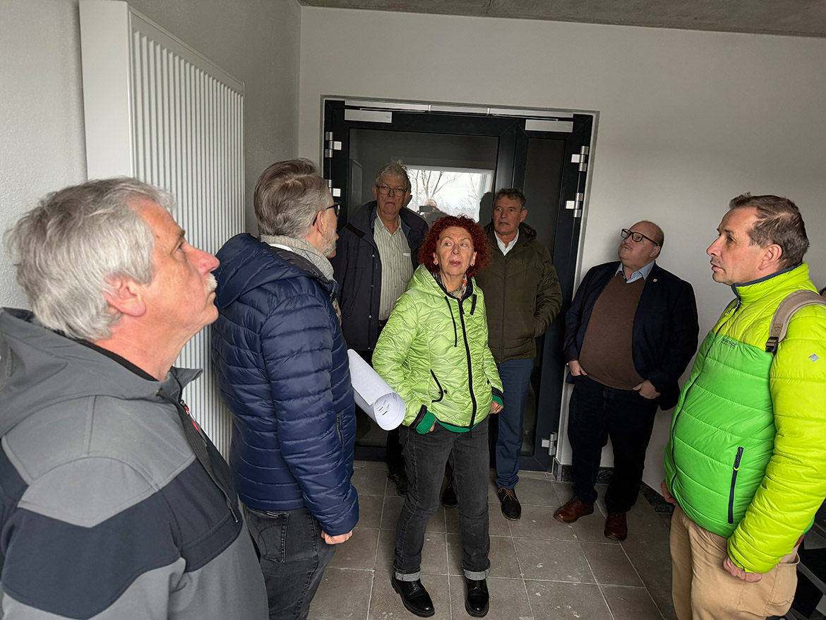 Einige Menschen stehen in einem Treppenhaus und schauen an die decke