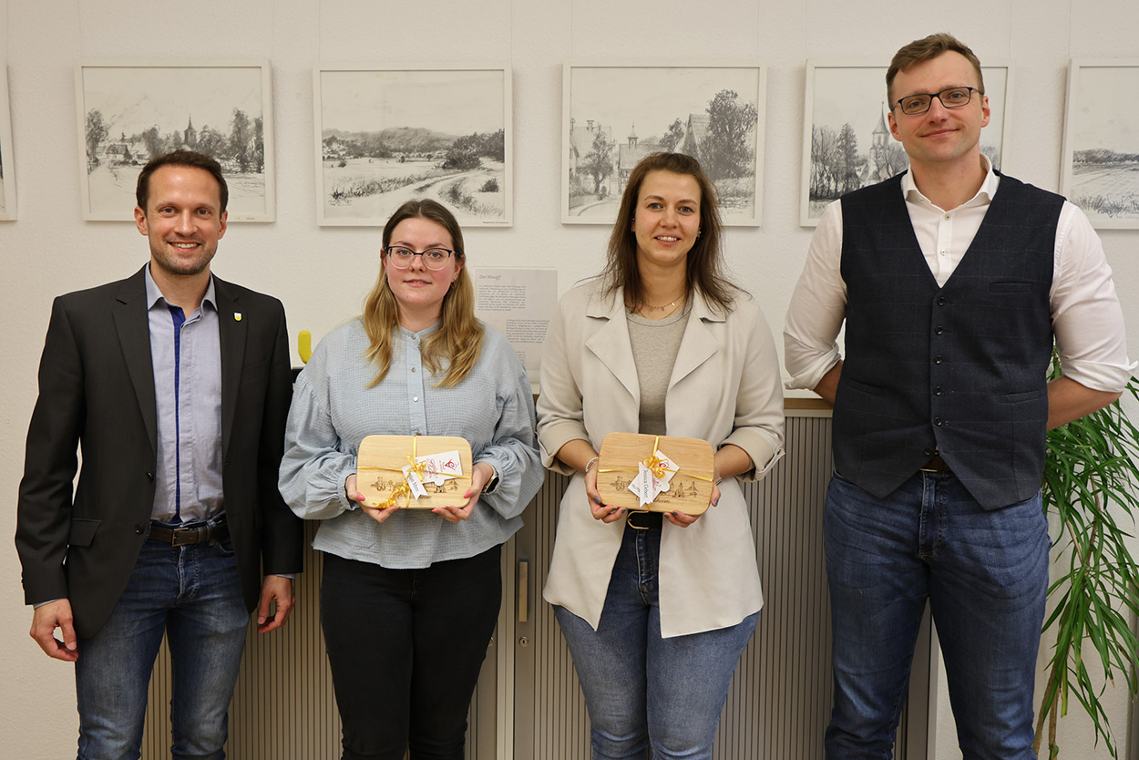 Zwei Frauen mit einer Auszeichnung in der Hand, flankiert von zwei Männern, lächeln in die Kamera