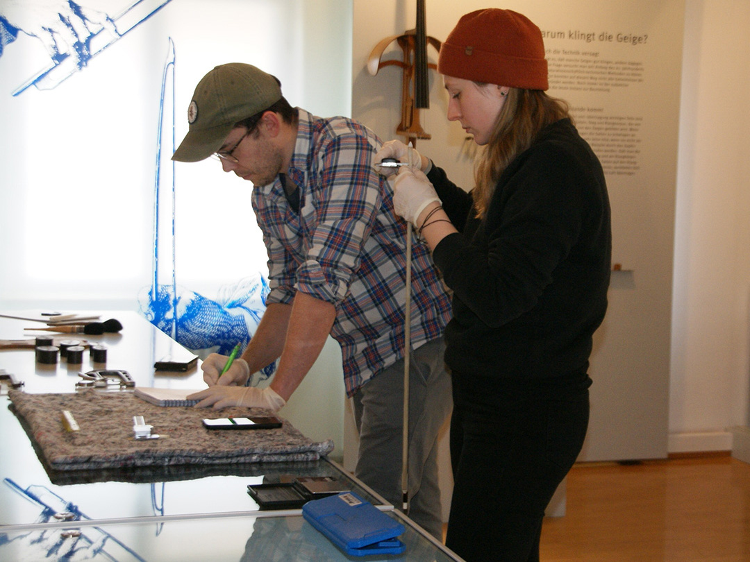 Ein Mann und eine Frau beschäftigen sich an einem Tisch mit Utensilien.