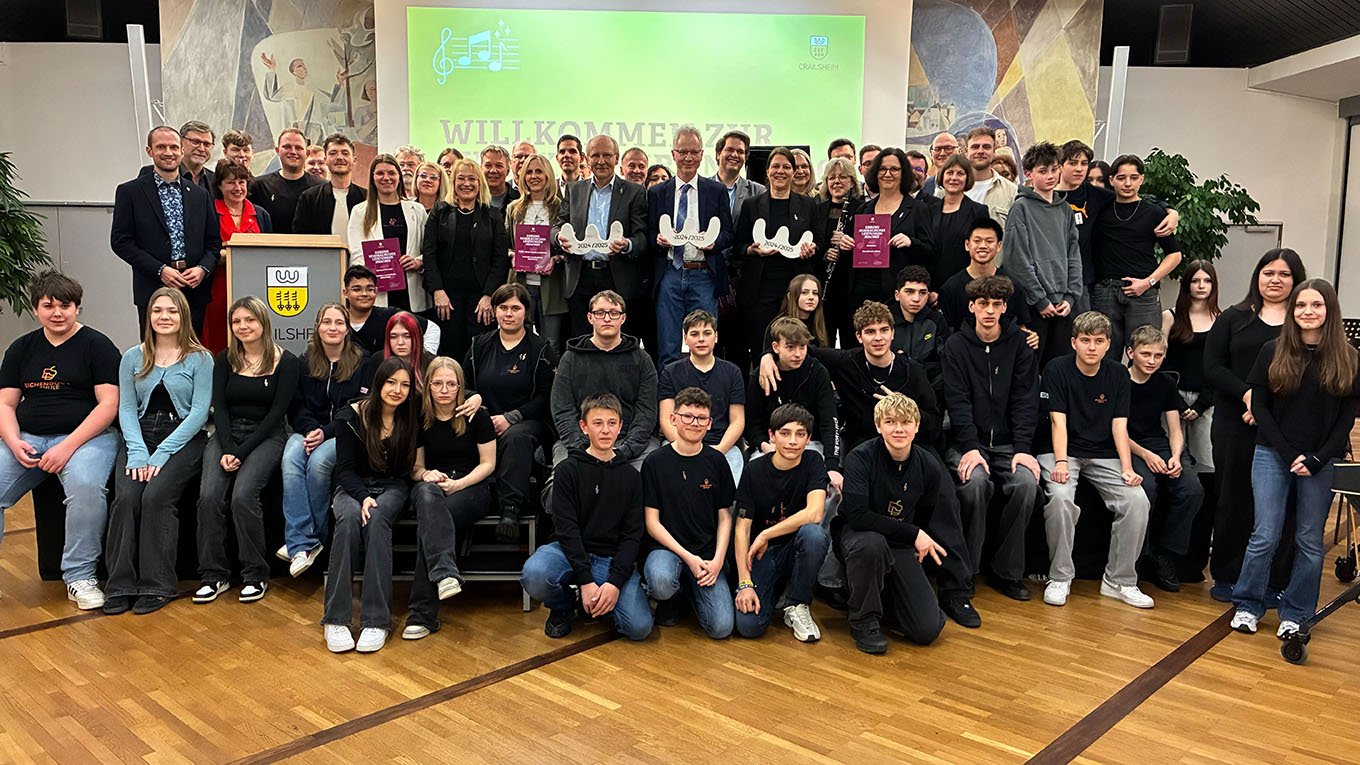 Eine große Gruppe Menschen, jung und alt, steht für ein Foto parat