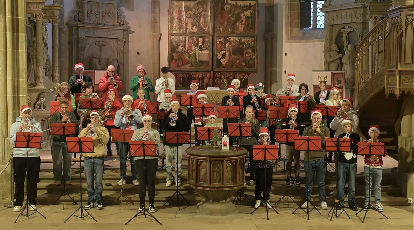 Stadtverwaltung Eine Gruppe Bläster steht mit Nikolausmützen auf dem Kopf in einer Kirche und spielen