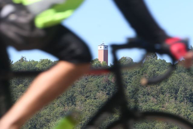 Radfahrer ist im Vordergrund und ein Aussichtstum im Hintergrund