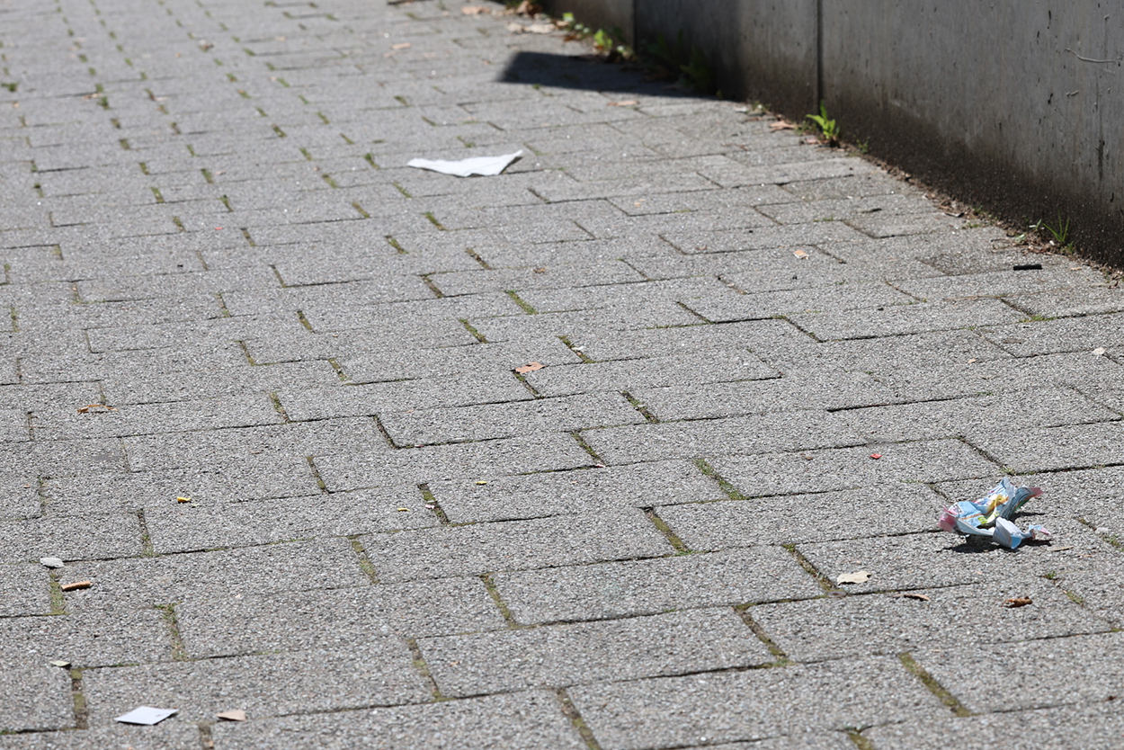 Stadtverwaltung Ein gepflasterter Gehweg mit ein paar Müllutensilien