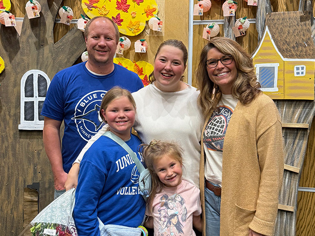 Eine Familie posiert lachend vor einer dekorierten Wand