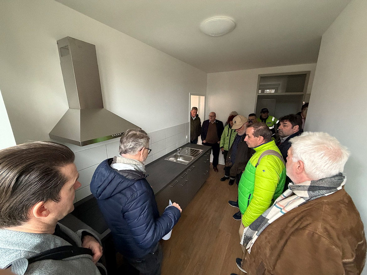 Einige Menschen stehen in einer neuen modernen Küche