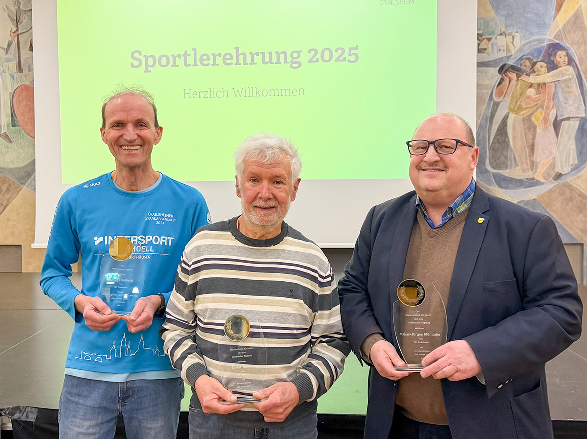 Drei Männer mit jeweils einer Auszeichnung in der Hand blicken in die Kamera.