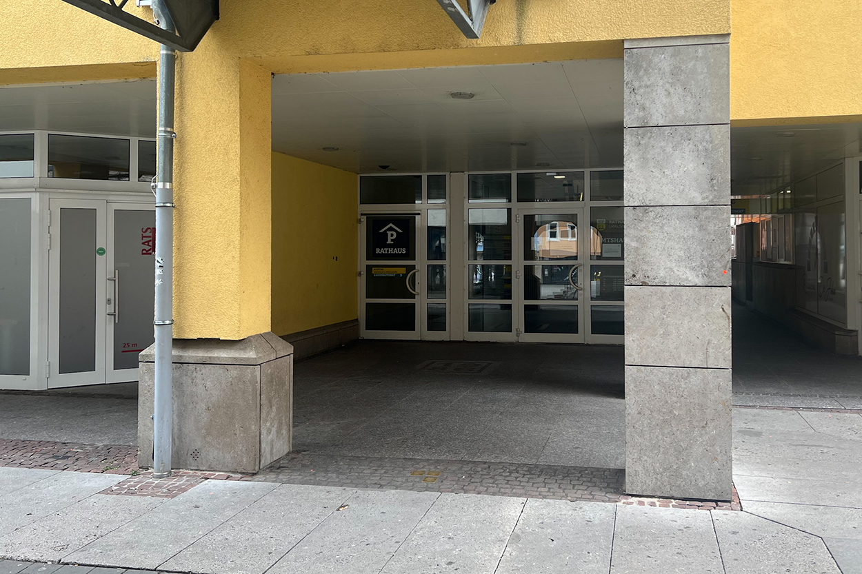 Eine Türe im Hintergrund unter einer Überdachung mit Säulen