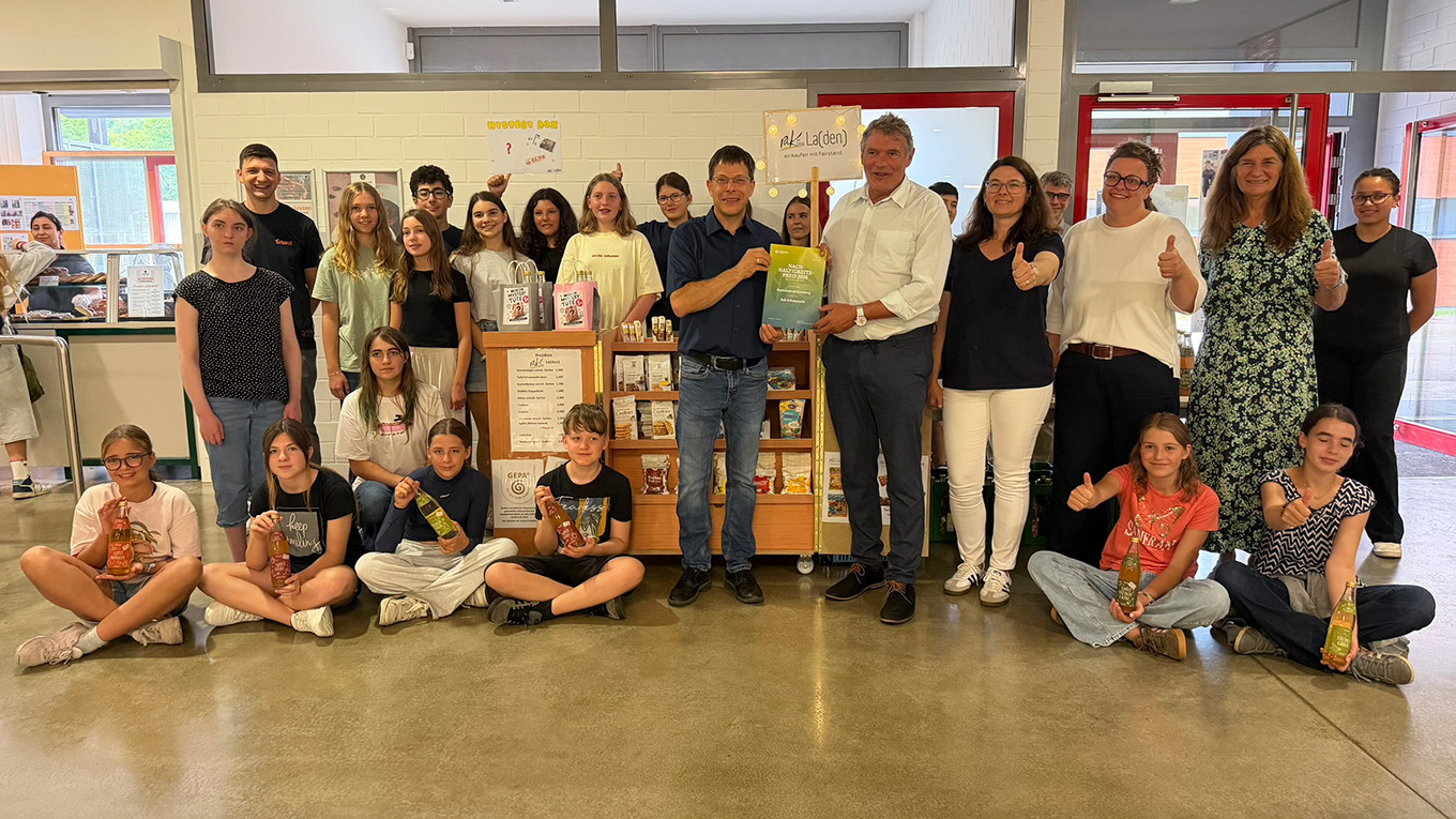 Schüler und Erwachsene stehen für ein Foto parat