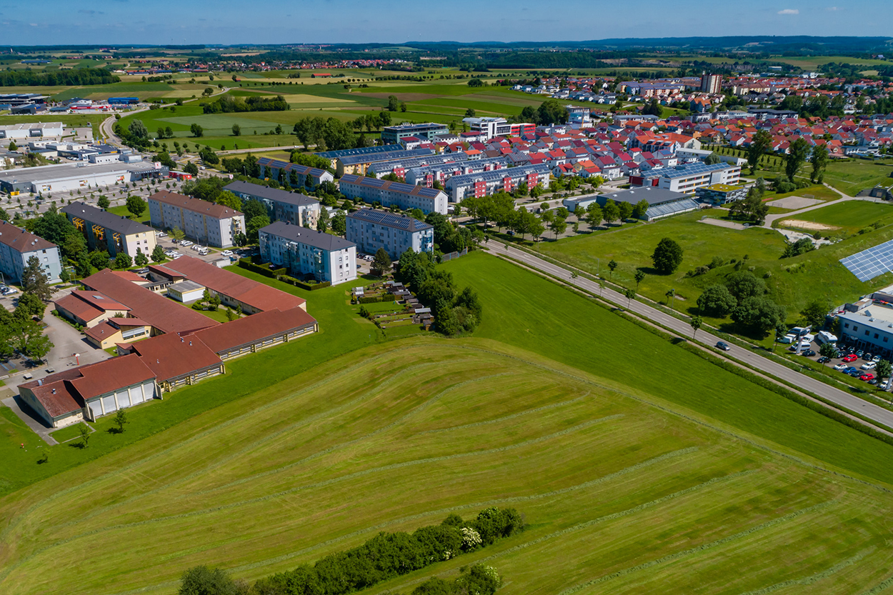 Stadtverwaltung Eine Luftansicht einiger Gebäude und freier Wiese.