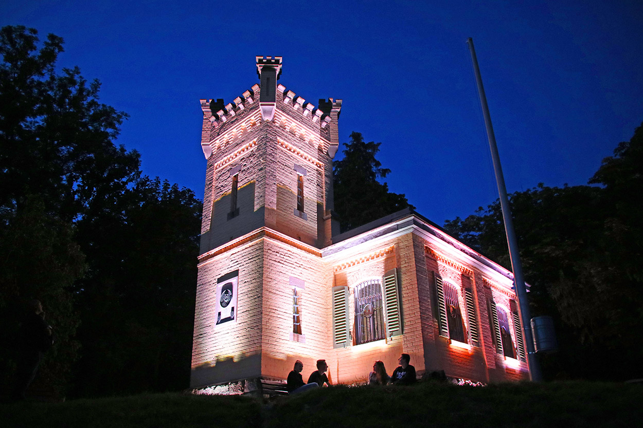 ein kleines Schlösschen in der Nacht, das beleuchtet ist